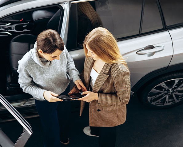 Two-women-conversing-near-a-parked-car Two-women-conversing-near-a-parked-car
