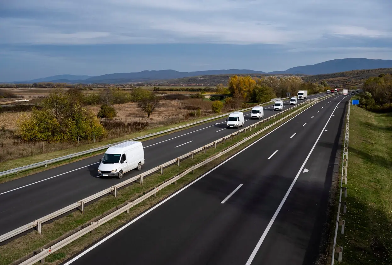 A large number of minivans move along the highway