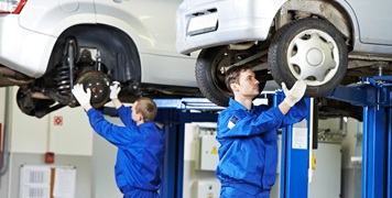 Auto mechanics working on car suspension
