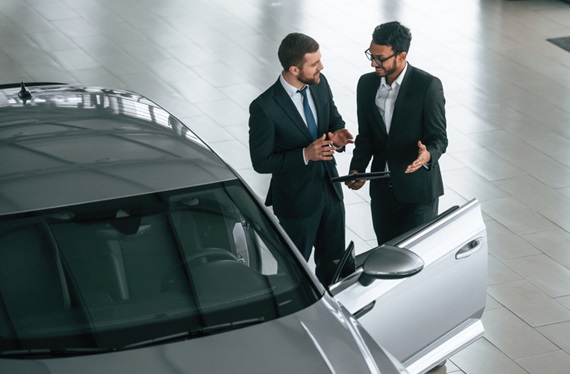 Man consulting with customer regarding vehicle sale and leaseback