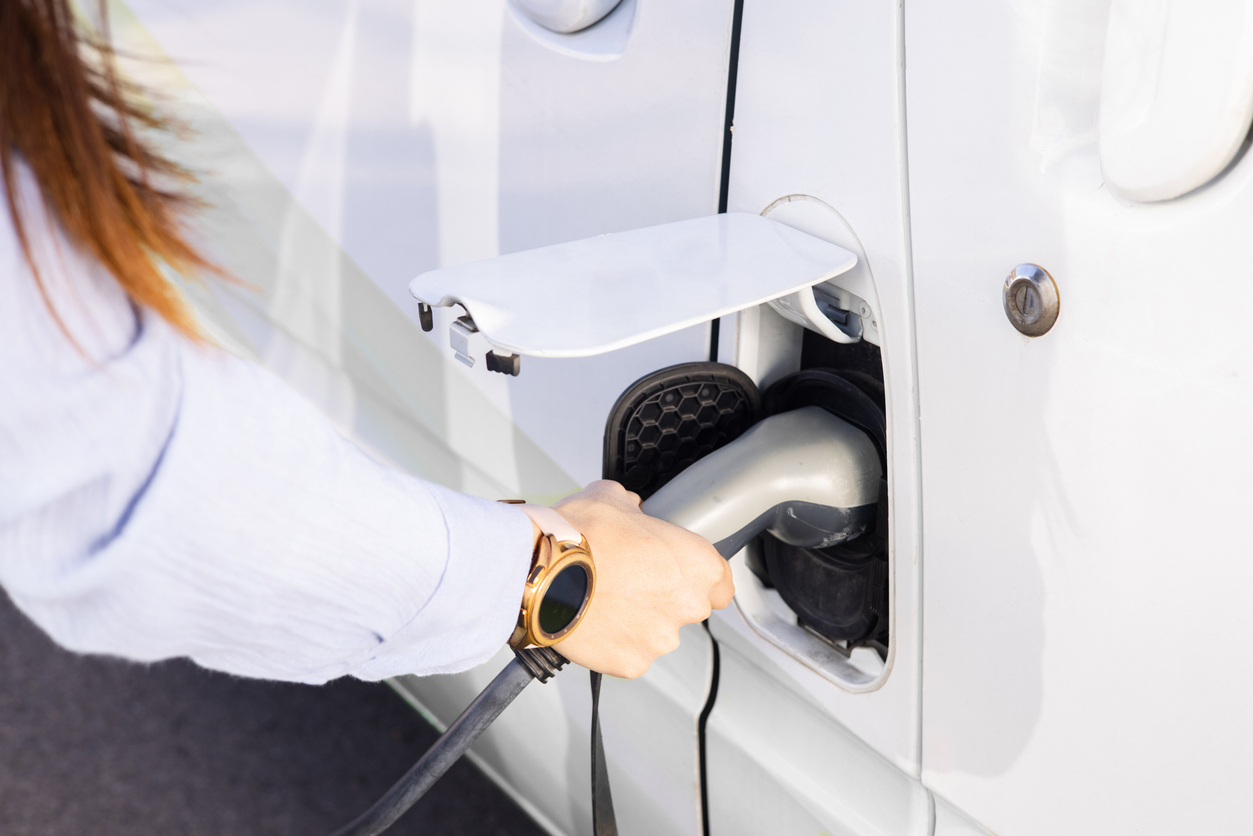 Unrecognizable woman charging the electric van