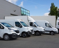 White Delivery Trucks backed Up to logistics retailer Warehouse building