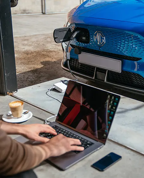MG ZS EV charging laptop at cafe