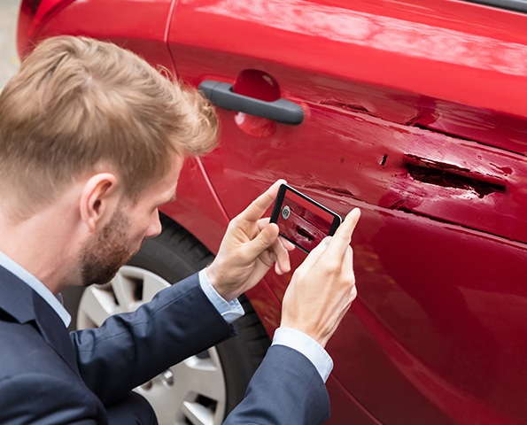 Man-takes-a-photo-of-his-car-damage Man-takes-a-photo-of-his-car-damage