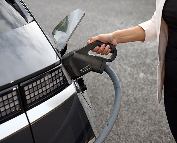 woman-charging-electric-vehicle woman-charging-electric-vehicle