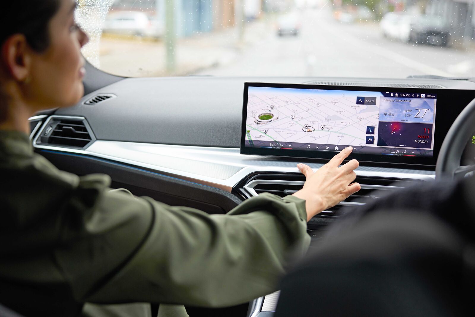 EV_Day_Couple_Driving_Navigation_2-medium Driver using a car's touchscreen display with navigation and vehicle data, illustrating modern fleet technology.