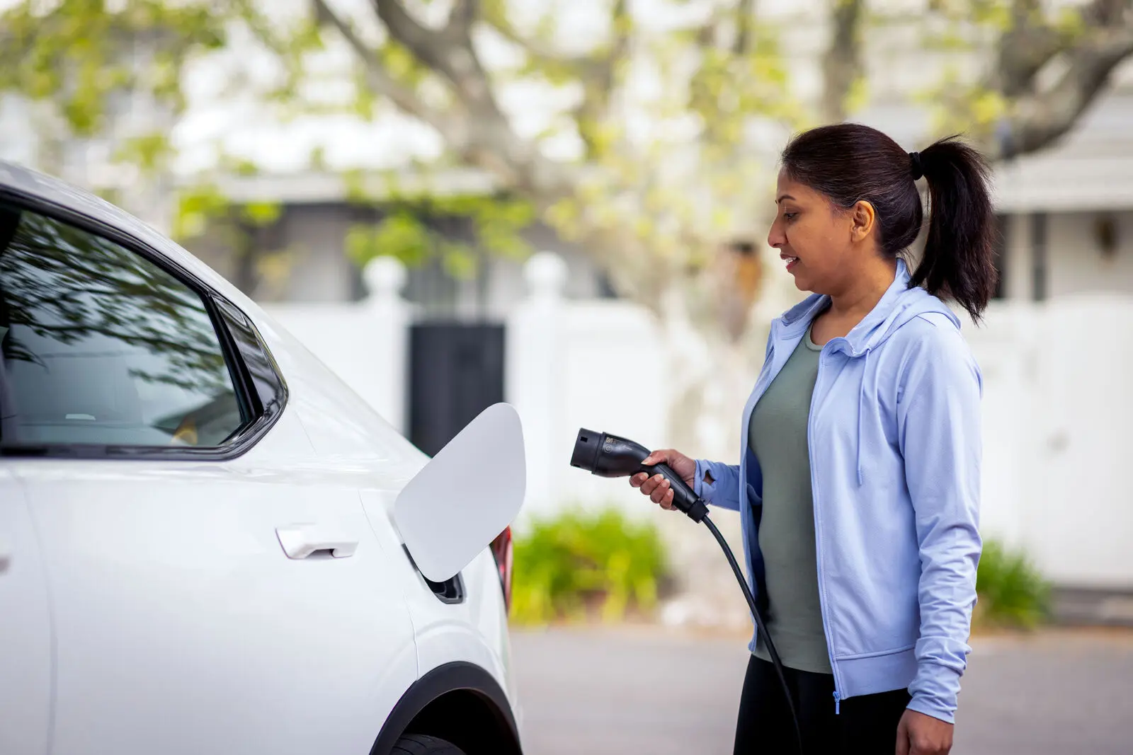 Woman charging electric vehicle