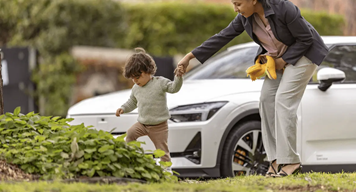 Woman with small child walking alongside the road