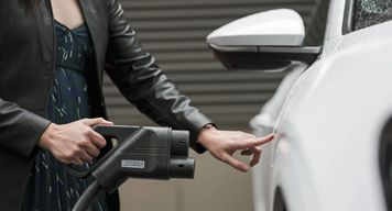 Woman plugging in EV charging cable