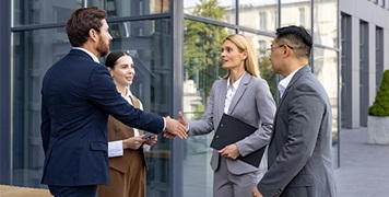 business-people-shaking-hands-outside-office-building