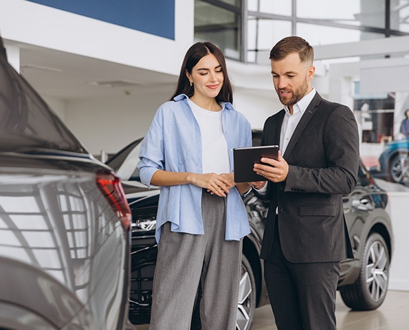 female-consulting-with-car-dealership-salesperson female-consulting-with-car-dealership-salesperson