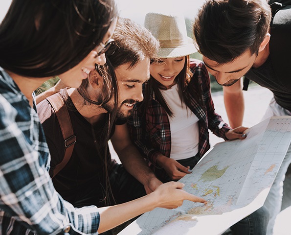 group-of-men-and-women-looking-at-world-map group-of-men-and-women-looking-at-world-map