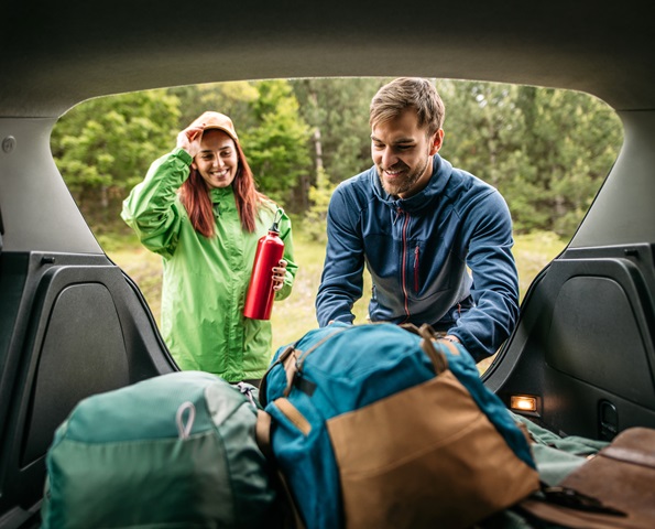 happy-couple-taking-bags-out-of-car-boot happy-couple-taking-bags-out-of-car-boot