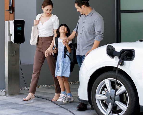 male-and-female-pictured-with-daughter-charging-ev-at-home male-and-female-pictured-with-daughter-charging-ev-at-home