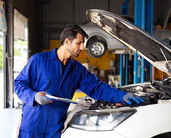 male mechanic repairs car in garage male-mechanic-repairs-car-in-garage