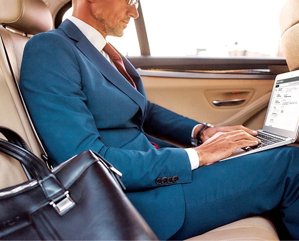 male-on-laptop-in-the-backseat-of-a-car