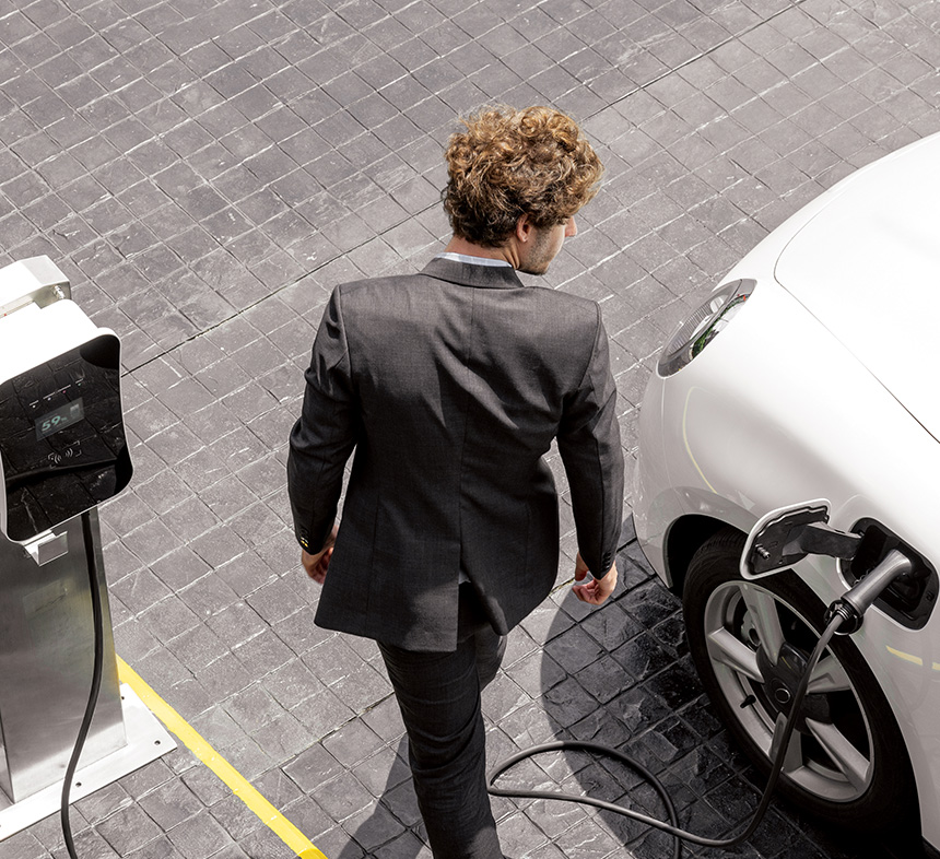 male-professional-charging-electric-vehicle-in-car-park
