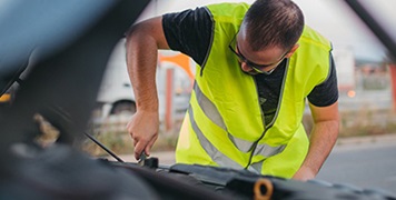 man-repairing-car-on-road