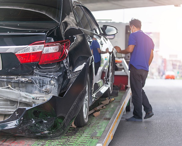 Tow Truck Transporting Car On Motorway Freeway. tow-truck-transporting-car-on-motorway-freeway