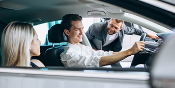 young-couple-buying-car-in-showroom