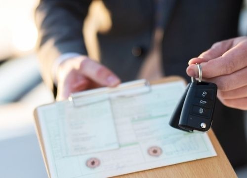 man holding clipboard with car keys