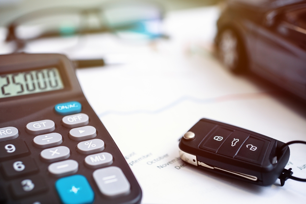 a calculator next to a set of car keys displaying tax and interest rates in the UK spring statement