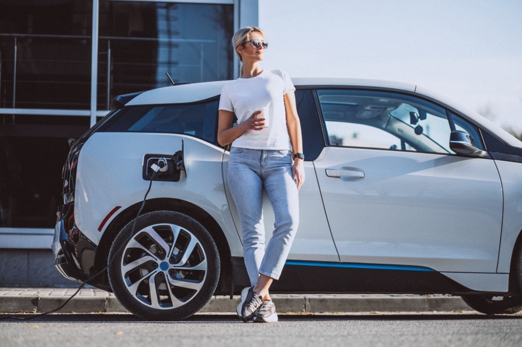 woman standing in front of electric vehicle